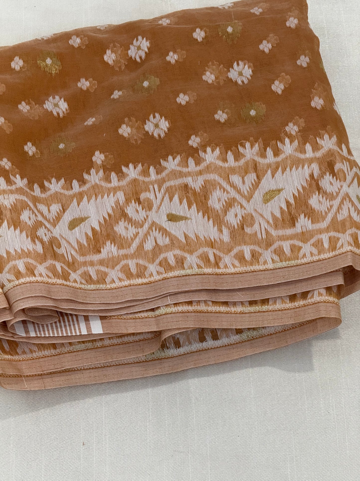 Jamdani weave close-up with delicate ivory floral buttas on biscuit-brown base