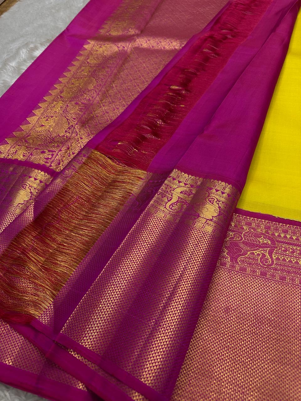 Crafted from pure Kanchipuram silk, this golden yellow saree features a broad pink border with traditional Yali motifs. The pallu is richly woven with bold elephant designs in thick zari—an elegant blend of heritage and grandeur.