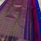 Sapphire Orchid celebrates the classic blue–purple pairing of Kanchi. The body is a rich sapphire/cobalt blue with tiny floral buttas in gold zari. A striking amethyst-purple korvai border and grid pavun Zari pallu Silk Mark Certified, delivery in 2 weeks