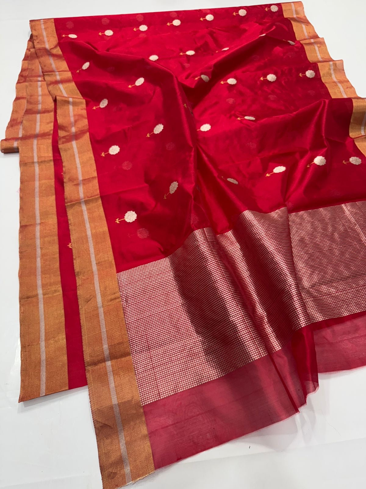 Roja Pushpam — Pure Silk Chanderi (Crimson Blossom)
Crimson red body with silver-ivory floral buttas & gold stems 🌸
Antique copper-gold border • Red-gold tissue pallu • Silk Mark Certified • Free Shipping within USA • Ships in Two Weeks
