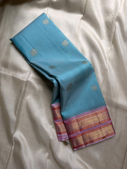 Nirvi – Sky Blue & Purple Kanchipuram Pure Silk Saree with Mayil & Yanai Zari Motifs
Graceful Harmony of Peacock & Elephant Motifs on Soothing Blue
Handwoven Elegance with Traditional Rettapet Border & Rich Zari Detailing