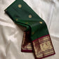 Pachai Butta – Pure Kanchipuram Silk Saree
Emerald silk scattered with radiant buttas.
A wine korvai border rich in gaja artistry.
Floral medallions glow in antique-gold zari.

Silk Mark Certified, delivery in 2 weeks