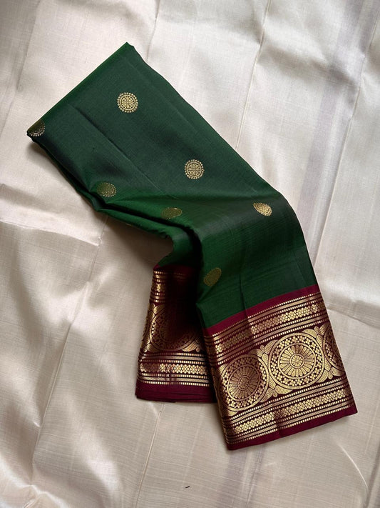 Pachai Butta – Pure Kanchipuram Silk Saree
Emerald silk scattered with radiant buttas.
A wine korvai border rich in gaja artistry.
Floral medallions glow in antique-gold zari.

Silk Mark Certified, delivery in 2 weeks