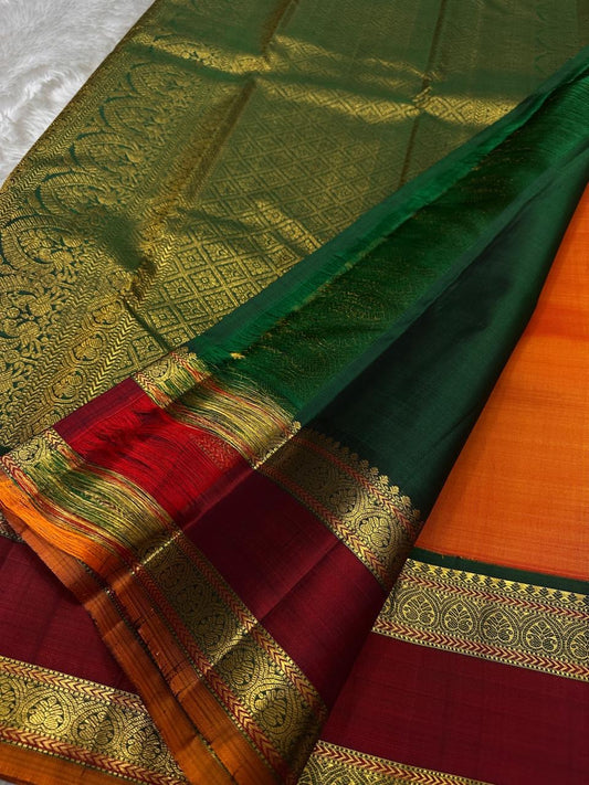 Orange Maragatha Korvai — Kanchipuram Pure Silk

Sunset aruna-orange body with delicate single zari butta

Deep maroon korvai borders with floral rosette motifs; green selvedge

Rich maragatha-green zari pallu (zari jaal & vine panels)..description