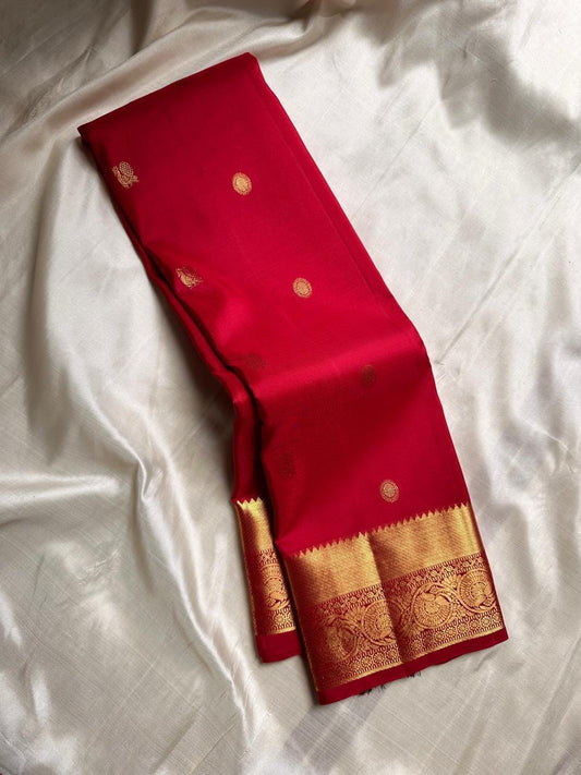Agnika – Red Kanchipuram Silk Saree with Mayil Chakram Butta & red Border Fiery and regal, Agnika is a pure Kanchipuram silk saree featuring a rich red body adorned with intricate Mayil Chakram buttas.