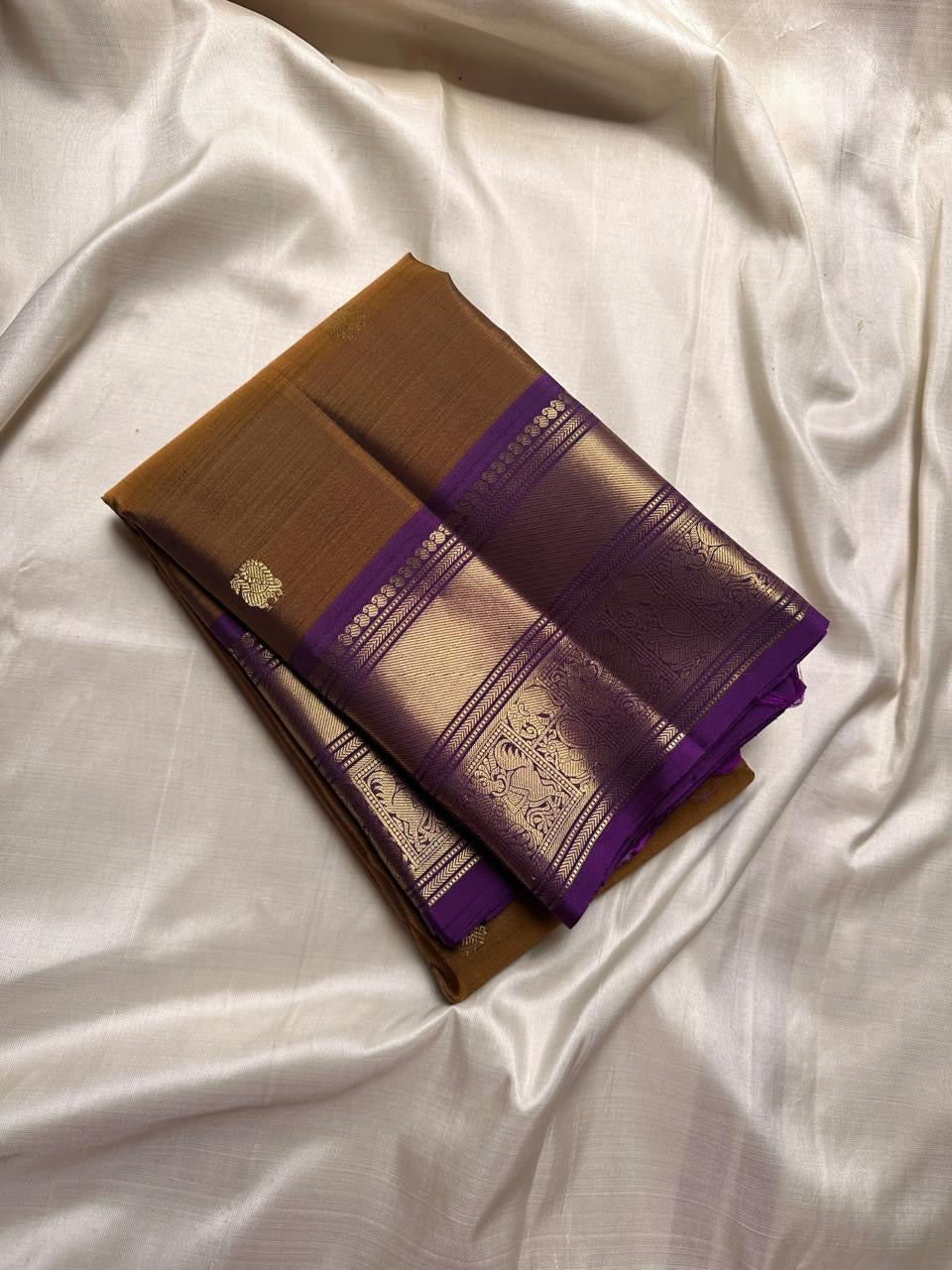 Ponvandu & Purple Butta — Pure Kanchipuram Silk Saree
Antique mustard body with gold zari buttas & rich purple borders
Peacock-woven zari motifs and temple serrations across the grand pallu
Silk Mark Certified • Free Shipping within USA • Ships in Two Wee