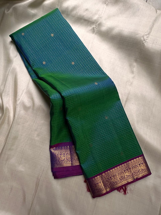 Nemaya – Green-Blue Shot Pure Silk Kanchipuram Saree with Peacock Zari Kattam & peacock with kamalam on  Border in purple . Ornate grid zari Pallu on purple comes with fully stitched padded blouse
