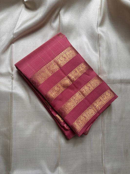 vasantham  pink – Handwoven Kanchipuram Silk Saree
A poem in pink silk. The body glows in a serene rose pink, softly accented by delicate gold vertical lines and dainty gold zari buttas that glint like little blessings.