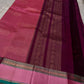 A regal magenta silk with intricate  zari buttas scattered delicately across the body. The border is a stunning blend of soft pink and teal, featuring fine gold silver  zari weaving and temple motifs