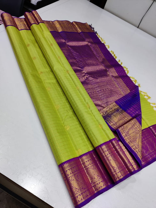Verdant Gold ✨ – Parrot Green & Violet Pure Kanchipuram Silk Saree
 Gold Zari Buttas in Kattam Weave
Violet Korvai Border with Peacock & Floral Zari Motifs
Grand Violet Brocade Pallu with  Tassels done 
Violet Blouse with Zari Border | Silk Mark