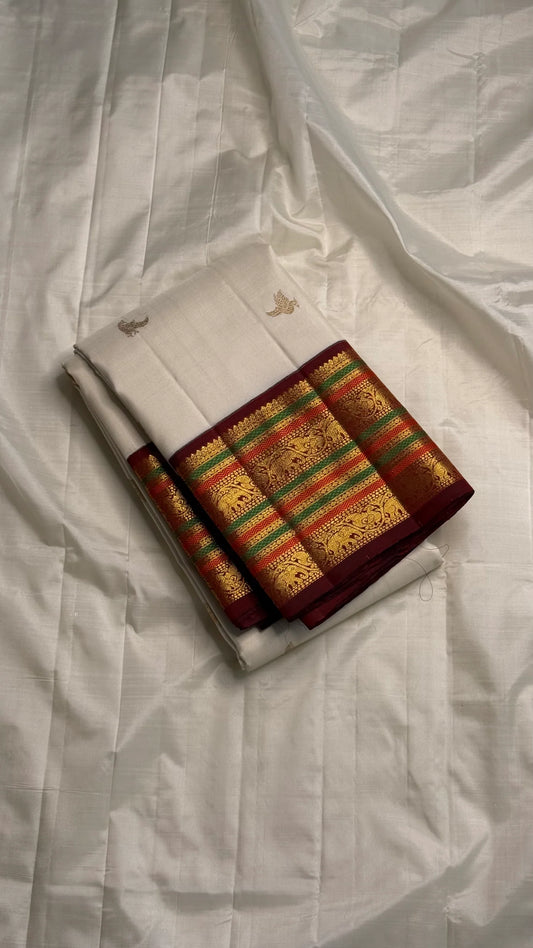 Parakkum Kili — Ivory Pure Silk Kanchipuram

Ivory body with fine zari coin buttas ✨
Rust-orange korvai borders with mayil & temple motifs 🌸
Grand rust-orange zari brocade pallu with tassels 🪔
Silk Mark Certified • Free Shipping USA • Ships in Two Weeks
