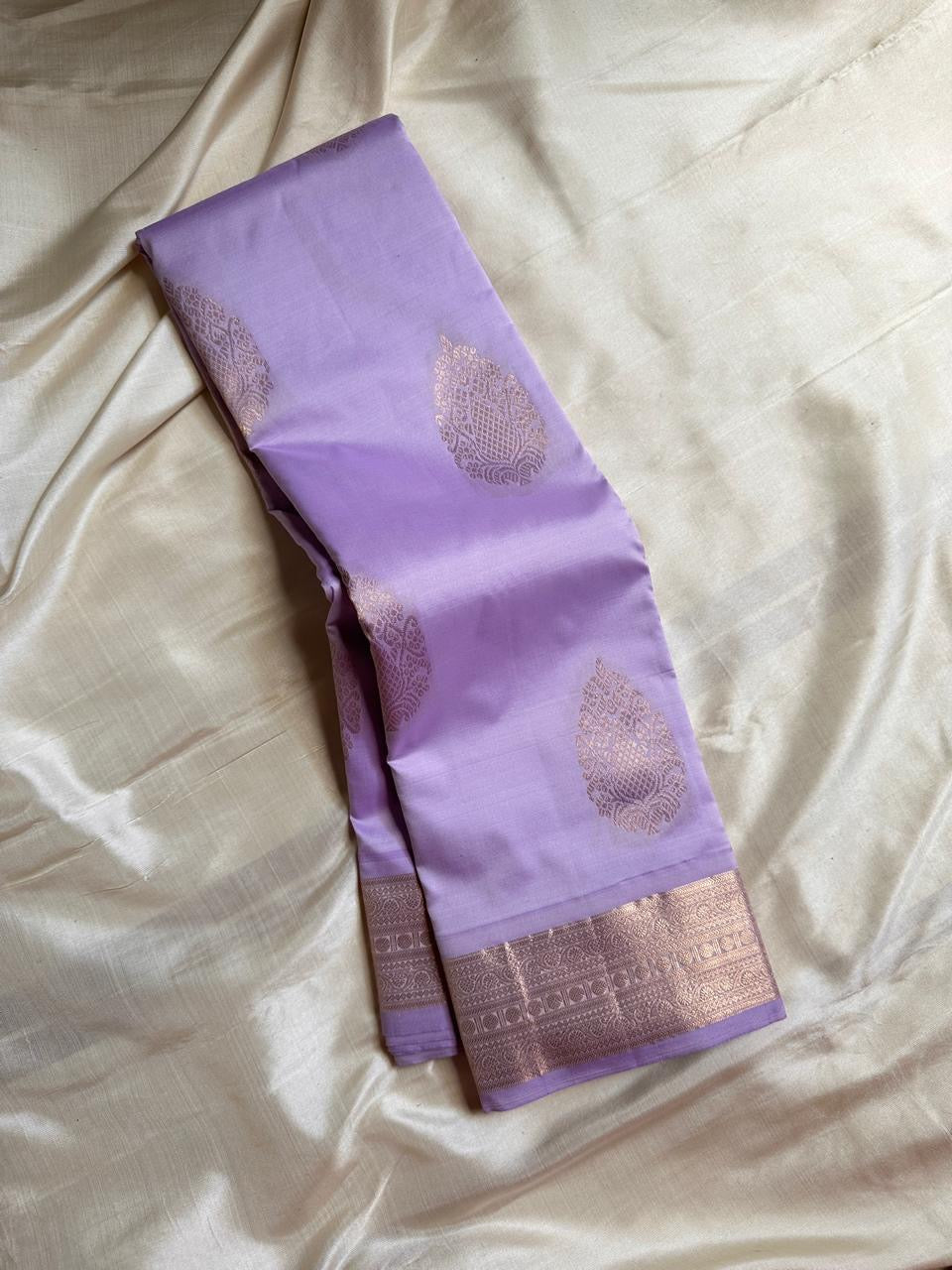 Thamarai Lilac — Pure Kanchipuram Silk Saree
Pastel Lilac with Rose-Gold Zari Leaf Buttas & Diamond Jaal Pallu
Silk Mark Certified • Free Shipping within USA • Ships in Two Weeks