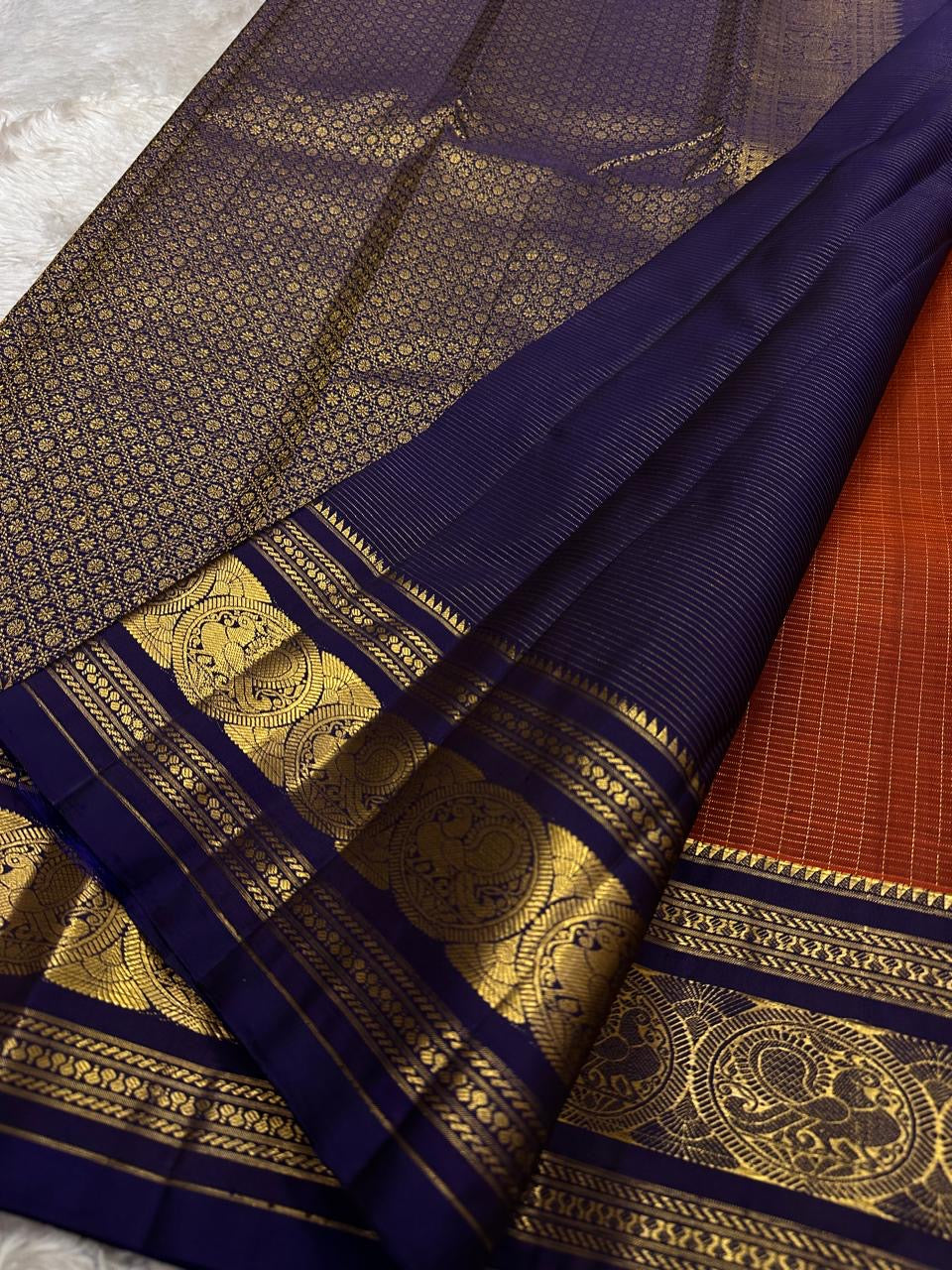 Rust Orange Sorgavasal Mayil – Pure Kanchipuram Silk Saree
Rust Orange Body with Petite Gold Zari Buttas ✨
Grand Navy Border with Sorgavasal mayil Peacock Motifs 🦚
Contrast Pallu in Rich Zari Weave 💫
Silk Mark Certified, delivery in 2 weeks