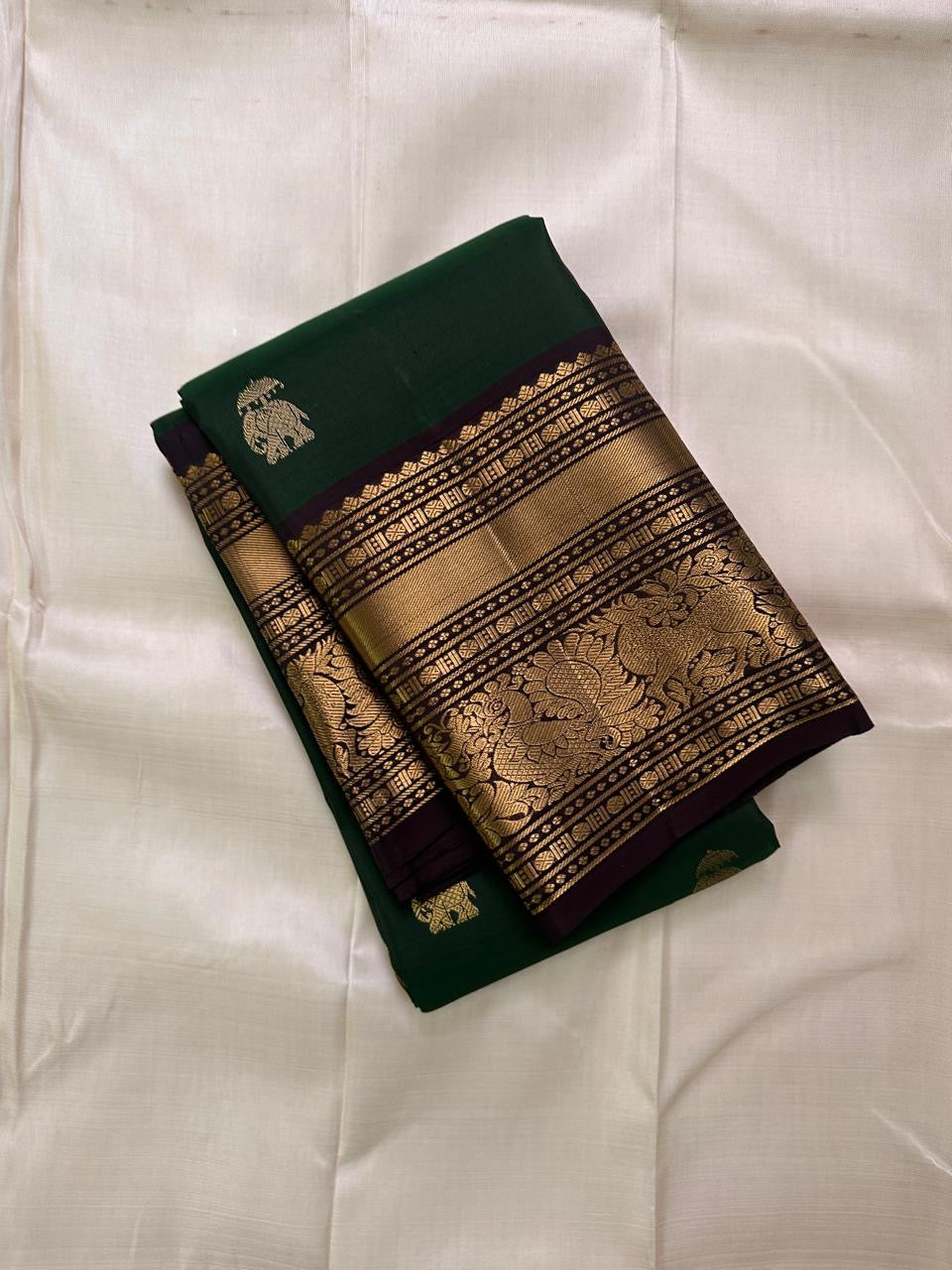 Emerald Green Elephant Butta — Pure Kanchipuram Silk Saree
Emerald green body with antique-gold zari elephant buttas and grand coffee-brown korvai borders featuring yali–mayil motifs.
Silk Mark Certified • Blouse Stitching Available ($30) • Free Shipping