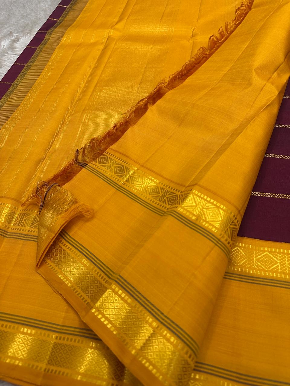 Close-up of mustard pallu on pure Kanchipuram silk saree with gold zari geometric motifs and silk texture, available in the USA.