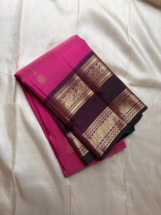 Anvitha – Magenta & Pink Shot Kanchipuram Pure Silk Saree
Glowing dual-tone silk body in radiant magenta and pink
Paired with a rich brown rettapet border featuring peacocks & floral vines in gold zari