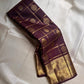 Folded view of plum Gandaberunda zari kattam Kanchipuram silk saree with rich gold elephant border on ivory base.