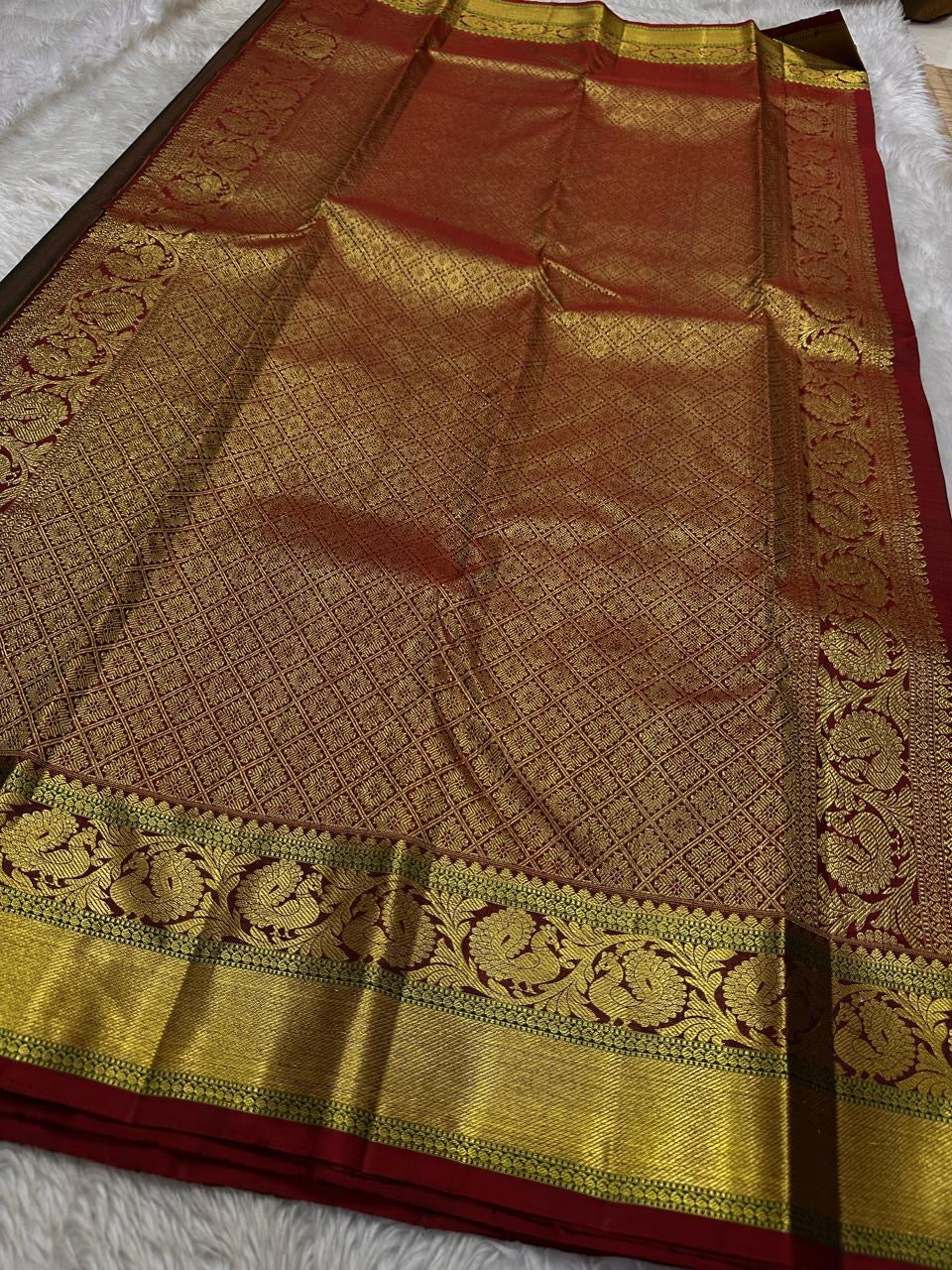 Emerald Glow ✨ – Pure Kanchipuram Silk Saree

Deep Green Body with Gold Floral Buttas

Maroon Korvai Border with Peacock & Floral Zari Motifs

Grand Gold Zari Brocade Pallu with Diamond Lattice Weave

Silk Mark Certified | Fall & Pico Done | Blouse Stitch
