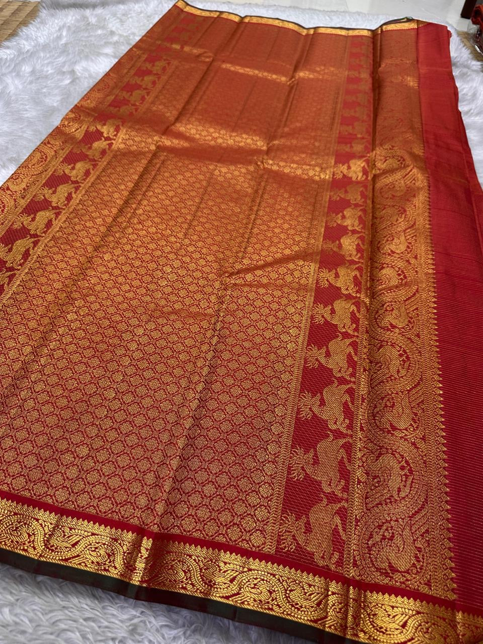 Red Vairaoosi Maan — Pure Silk Kanchipuram Saree
Vibrant crimson-red body in fine vaira oosi weave with gold maan (deer) motifs 🦌
Antique-gold zari borders, copper brocade pallu & dark selvedge detailing ✨
Silk Mark Certified • Free USA Shipping • Ships