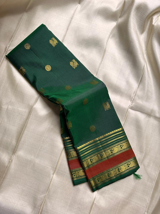 Minnal ✨ – Forest Green Kanchipuram Pure Silk Saree
with Radiant Gold Coin Buttas 🌸
Rust Korvai Varisaipet Zari Border
Grand Green Pallu with Gold Stripes & Panels