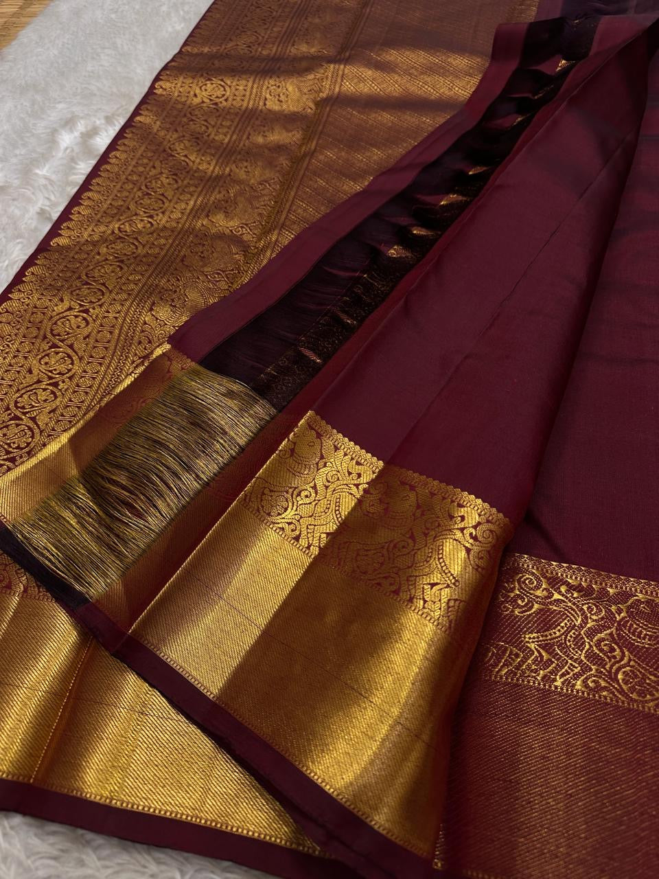Tanvi – Coffee Brown Kanchipuram Pure Silk Saree with Floral Zari Jaal & Baavanji Border

Rich coffee brown silk adorned with delicate floral zari jaal creates a timeless elegance.
The bold Baavanji border and grand Varisaipettu pallu