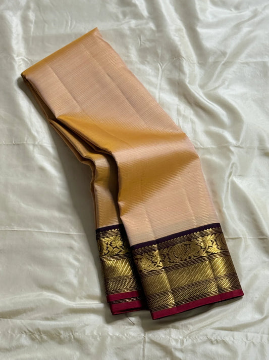 Sandhya 🌅 – Sun-Kissed Beige Kanchipuram Silk Saree with Subtle Vairaoosi Gold Filament ✨, Deep Purple Peacock Diamond-Pettu Zari Border 🦚, Deep Maroon Selvedge, and Zari-Embellished Pallu with Arai Maadam & Khalasam Motifs 🌿💛