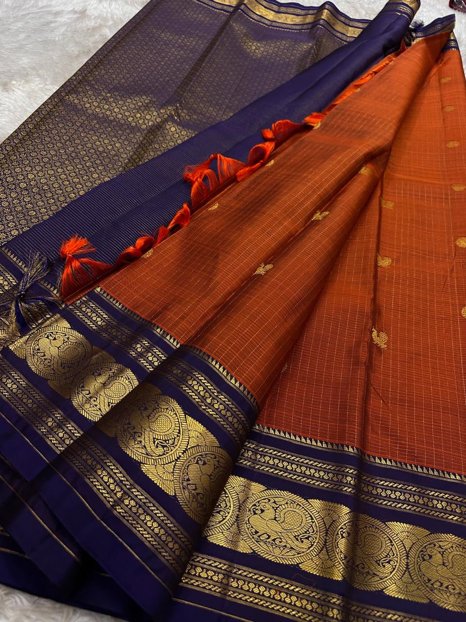 Rust Orange Sorgavasal Mayil – Pure Kanchipuram Silk Saree
Rust Orange Body with Petite Gold Zari Buttas ✨
Grand Navy Border with Sorgavasal mayil Peacock Motifs 🦚
Contrast Pallu in Rich Zari Weave 💫
Silk Mark Certified, delivery in 2 weeks
