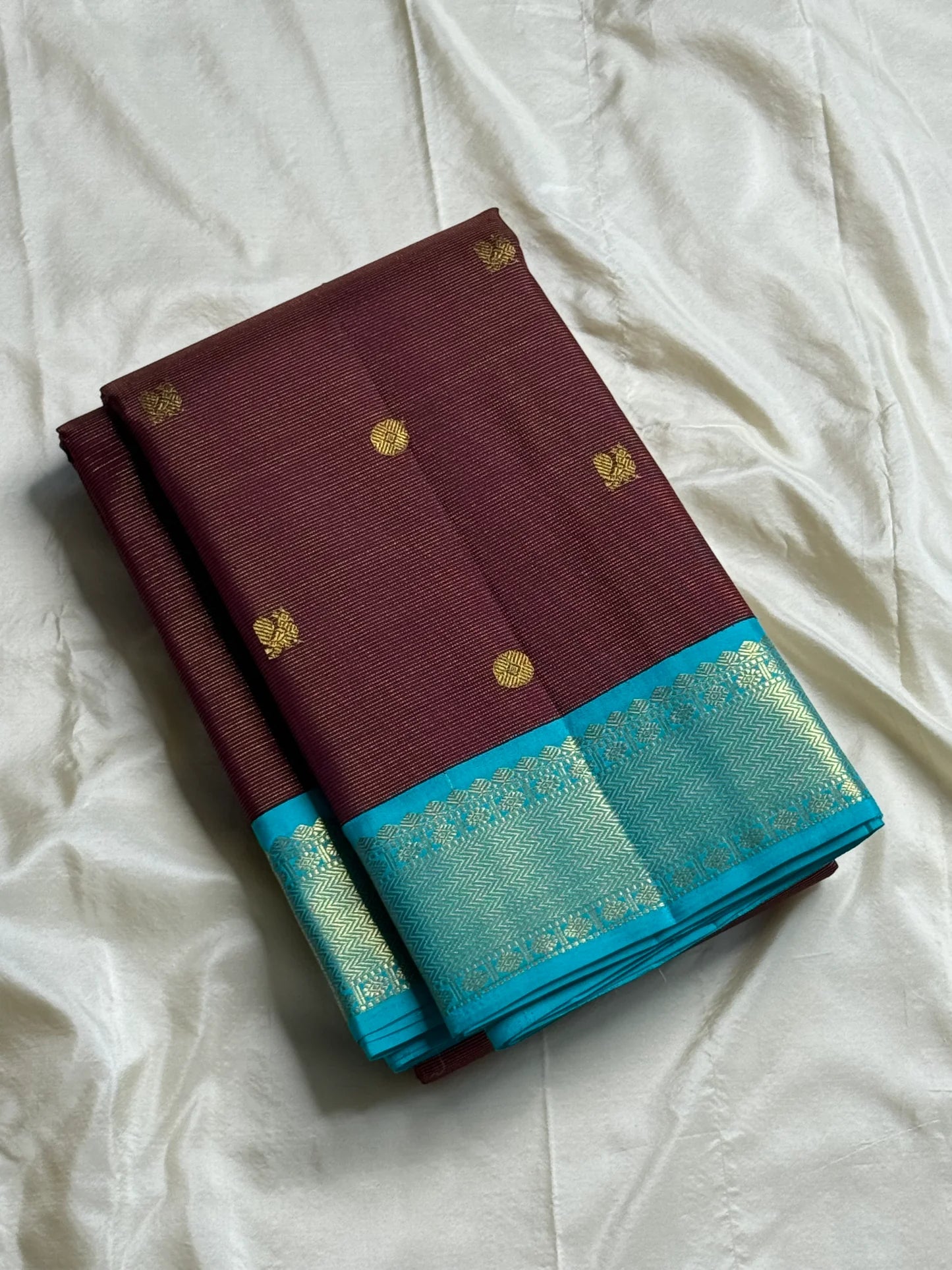Rathi – Earthy Brown Vairaoosi Silk Saree with Petite Kamalam & Chakram Buttas, featuring a finely Woven Muthu Seer Zari Border in a Classic Style
Pallu in Soothing Rama Blue with Grid-Like Zari Motifs of Paisley & Chakram