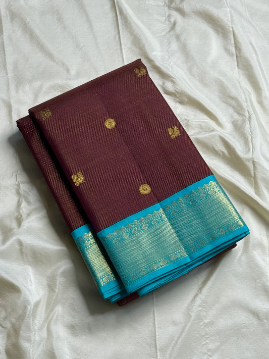 Rathi – Earthy Brown Vairaoosi Silk Saree with Petite Kamalam & Chakram Buttas, featuring a finely Woven Muthu Seer Zari Border in a Classic Style
Pallu in Soothing Rama Blue with Grid-Like Zari Motifs of Paisley & Chakram