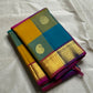 Rangoli Kattam – Pure Silk Kanchipuram Saree
Vibrant multicolor kattam checks with golden zari buttas across the body
Rich rani pink pallu with intricate zari weaving for a grand finish
Contrast purple borders edged with gleaming zari motifs