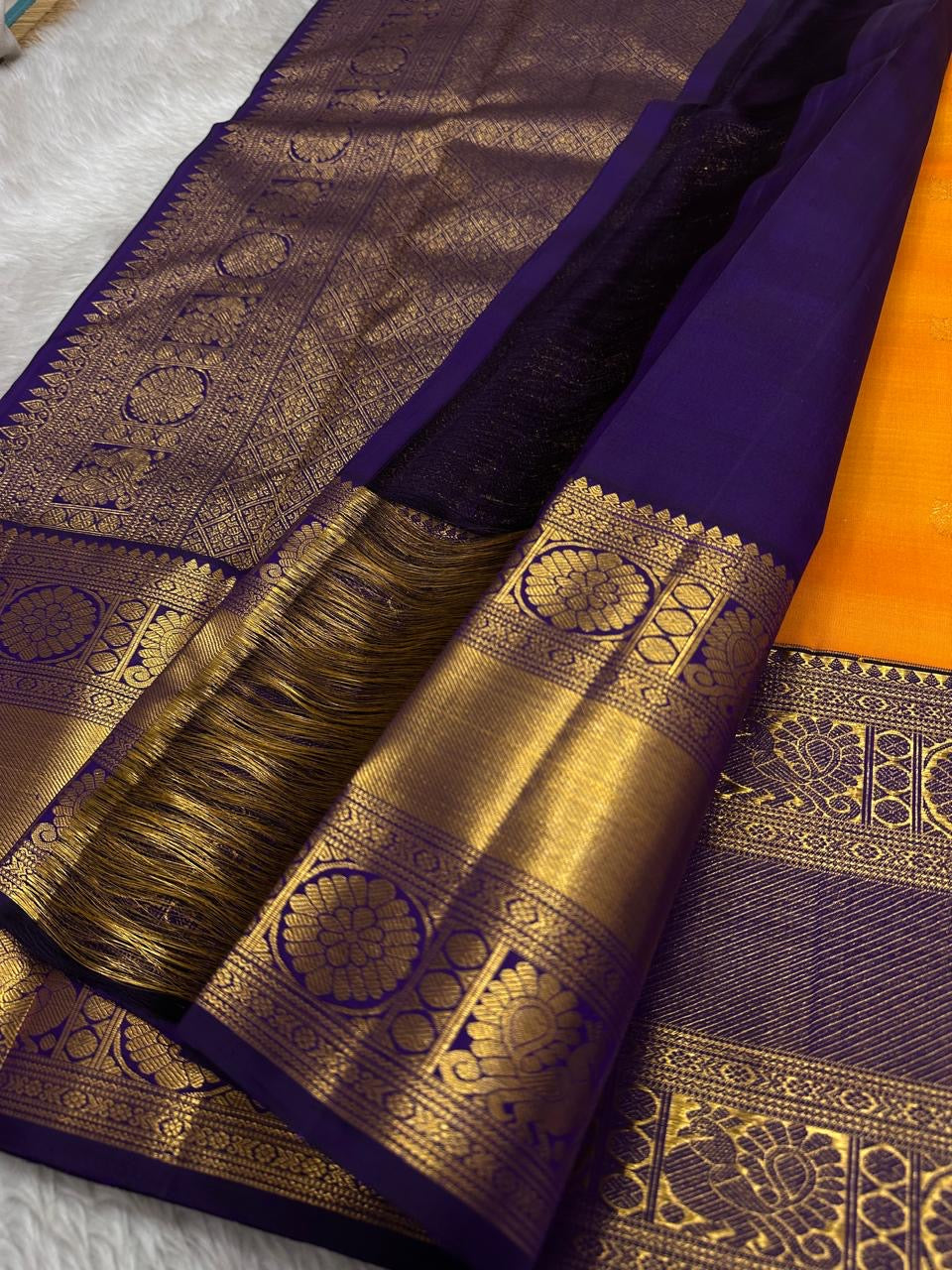 This Maambazha yellow Kanchipuram silk saree features zari mayil buttas and a deep blue rettapet border with kamalam motifs — a timeless blend of tradition and grace.