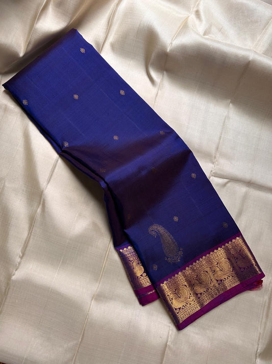 Pure silk violet shot with ink blue with zari kamalam butta and purple border with peacock motifs . Richly adorned Pallu with rudhraksh and kolam motifs