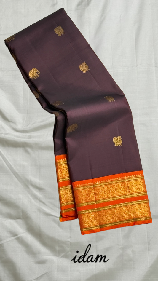 Deep Cocoa Manjari — Pure Kanchipuram Silk Saree
Rich cocoa-aubergine body with antique-gold manjari buttas, paired with a radiant kavi-orange korvai border and green selvedge accent.
Silk Mark Certified • Blouse Stitching Available ($30) • Free Shipping