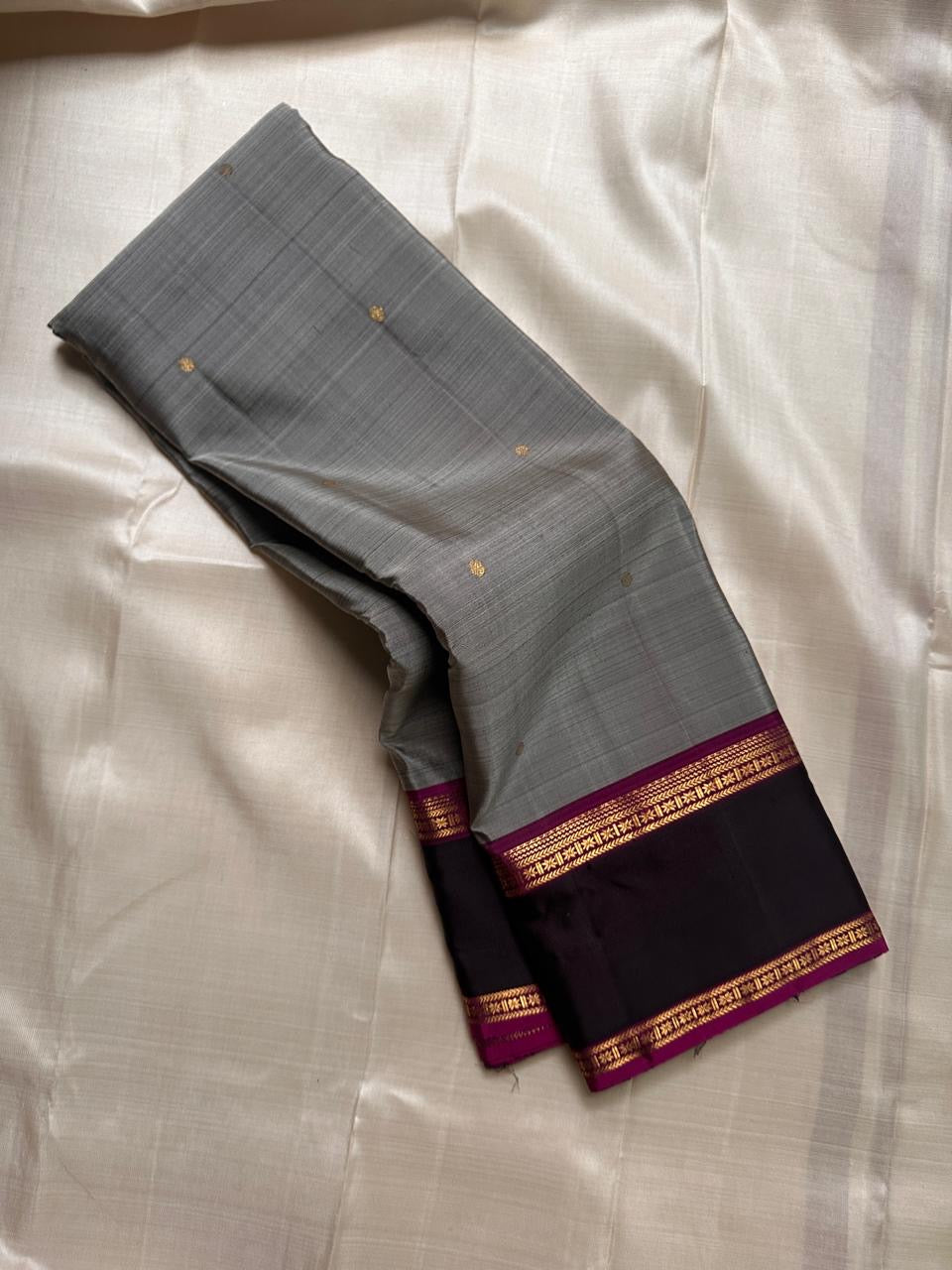 Ash Gulabi Chakram — Pure Kanchipuram Silk Saree
Elegant ash-grey body with gold zari chakram buttas, rich gulabi korvai borders, and deep violet zari pallu.
Silk Mark Certified • Blouse Stitching Available ($30) • Free Shipping within USA • 2 weeks