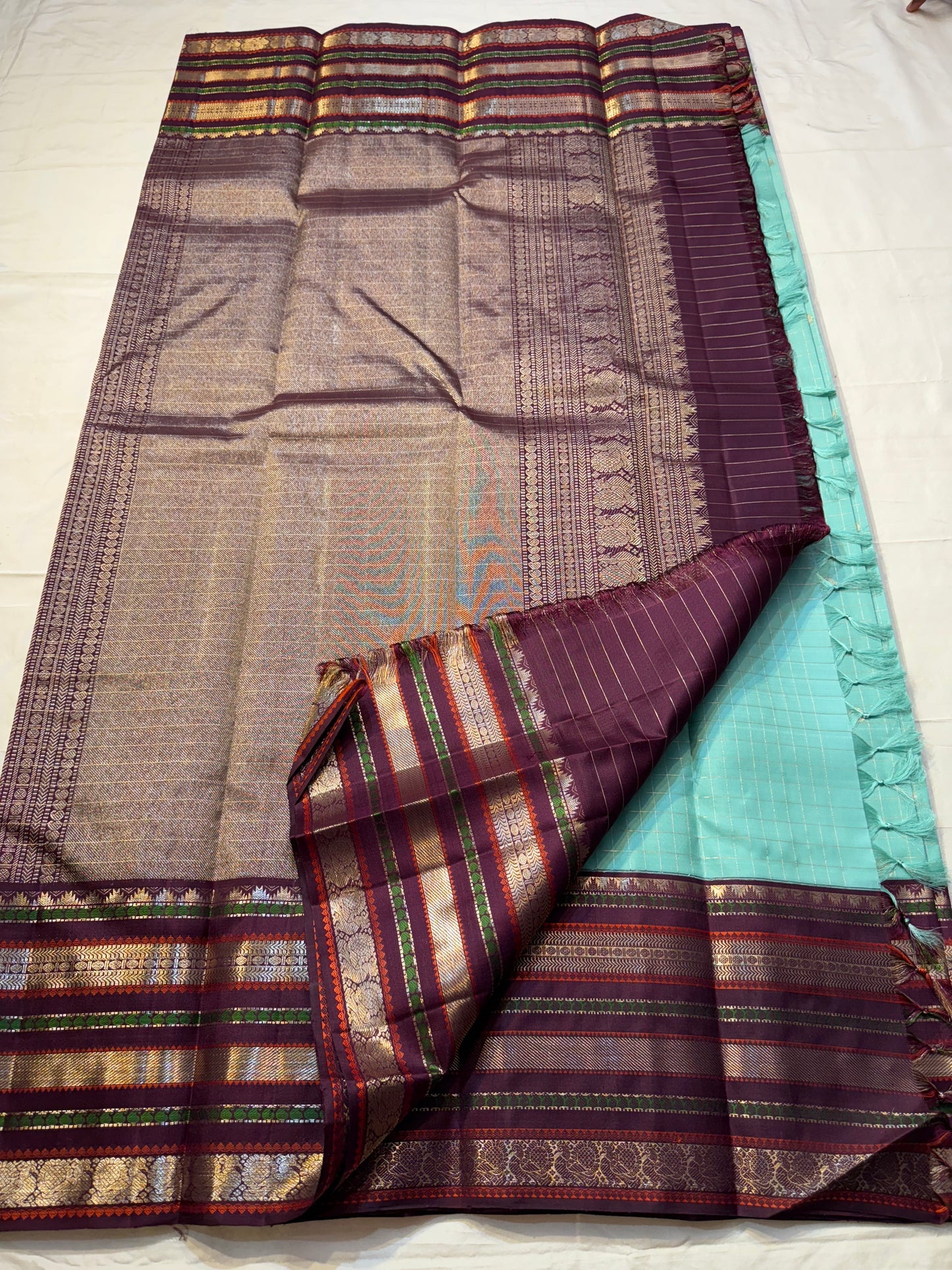Teal Mint Muthu Kattam — Pure Silk Kanchipuram Saree
Teal-mint body with tiny  zari  buttas & plum-maroon korvai borders
Silk Mark Certified • Free USA Shipping • Ships in Two Weeks