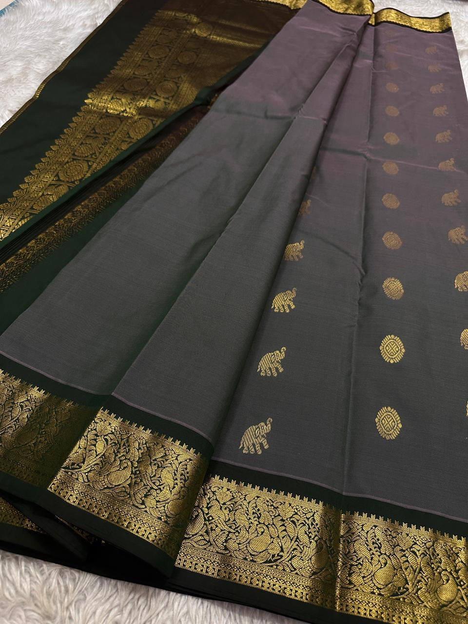Charcoal Pachai Yaanai – Pure Korvai Kanchipuram Silk Saree
Charcoal grey body with gold zari yaanai & medallion buttas
Deep pachai korvai border with peacock & vine motifs; grand brocade pallu
Silk Mark Certified | Fall & Pico Done | ship in two weeks