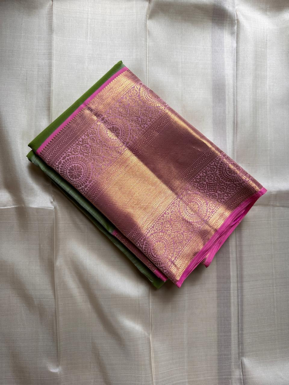 Spring green Kanchipuram silk saree with pink zari woven border, folded product view