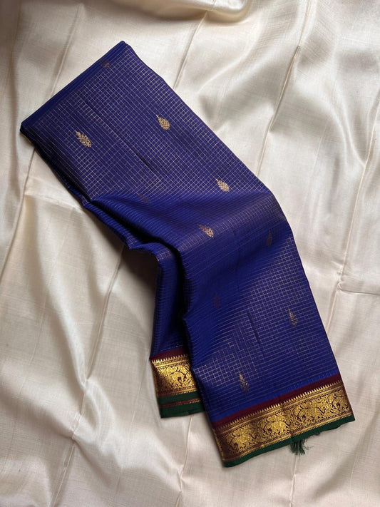 Midnight Oosikattam ✨ – Pure Kanchipuram Silk Saree
Deep Midnight Blue Body in Oosi Zari Kattam with Leaf Buttas
Maroon Korvai Border with Green Selvedge & Elephant Motifs
Opulent Maroon Pallu with Intricate Gold Zari Brocade
Silk Mark Certified |