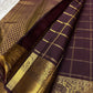 Close-up of plum Kanchipuram silk saree showing Gandaberunda zari kattam checks, intricate gold elephant border and tasselled pallu.