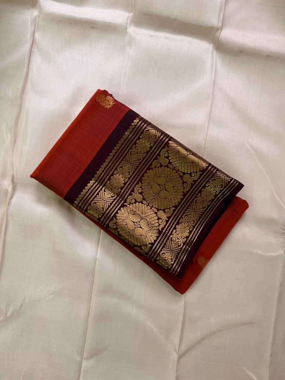 Rust Orange Coffee Brown — Flower Butta | Pure Kanchipuram Silk Saree
Rust-orange body with dainty zari-woven flower buttas and grand coffee-brown korvai borders rich in antique-gold floral medallions.
Silk Mark Certified • Blouse Stitching Available ($30
