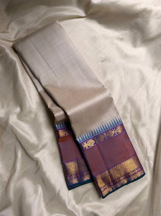 Vaidhehi – Ivory Kanchipuram Silk Saree
A classic ivory silk saree with a shot purple-orange Rudraksham border and a rich Thazhampoo reku pallu—timeless elegance woven with tradition