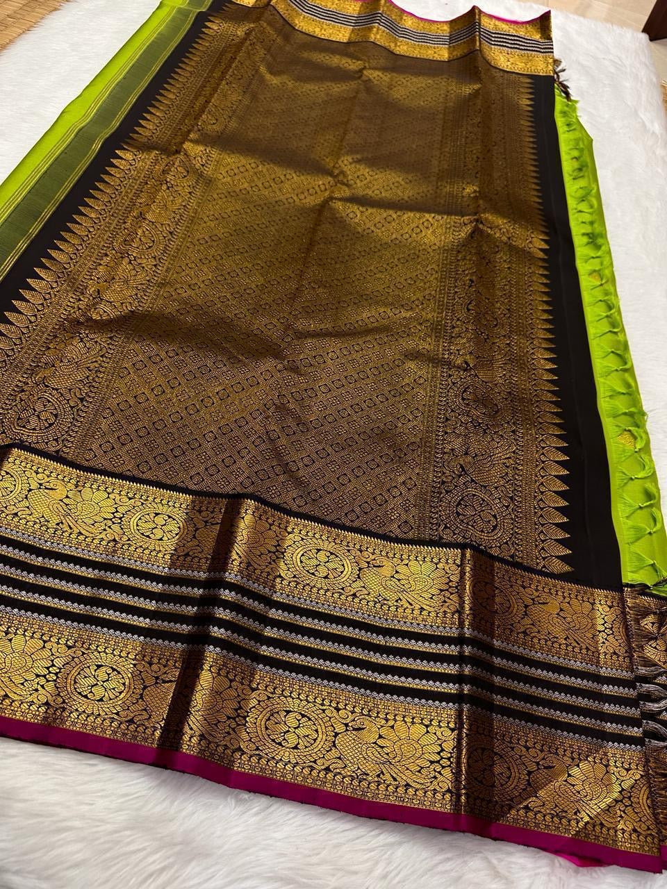 Kili Pachai — Pure Silk Kanchipuram Saree
Parrot-Green Body with Gold Buttas ✨
Black Korvai Borders with Peacock Medallions 🦚
Black Brocade Pallu • Contrast Black Blouse with Zari 🌸
Silk Mark Certified • Free Shipping within USA • Ships in Two Weeks