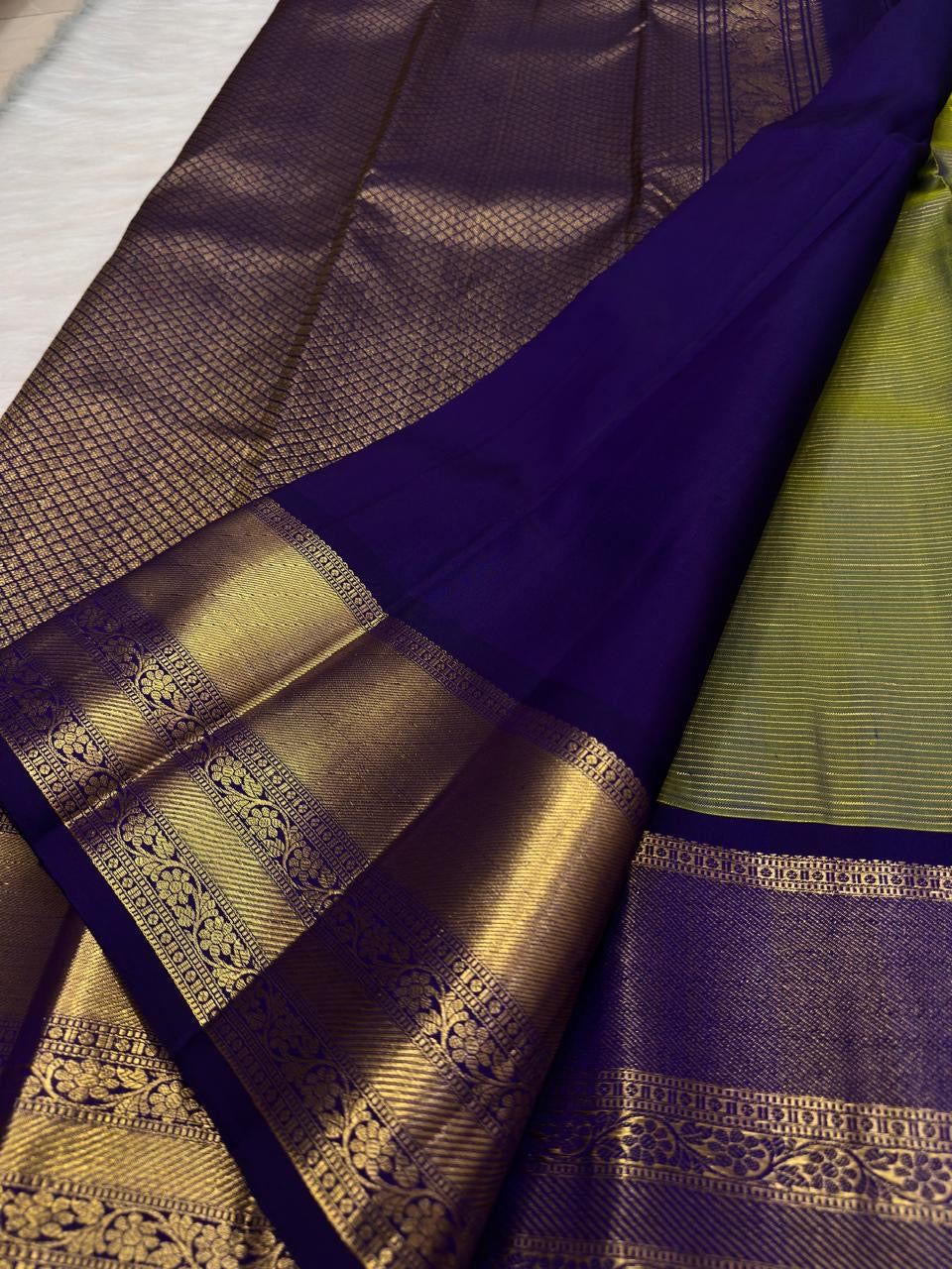 Elaborate royal purple zari pallu on olive green pure silk Kancheepuram saree