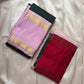Folded deep green and lavender Kanchipuram silk saree showing contrast border

