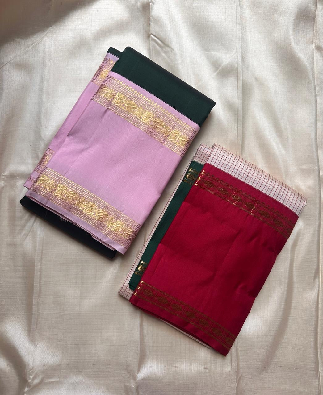 Folded deep green and lavender Kanchipuram silk saree showing contrast border
