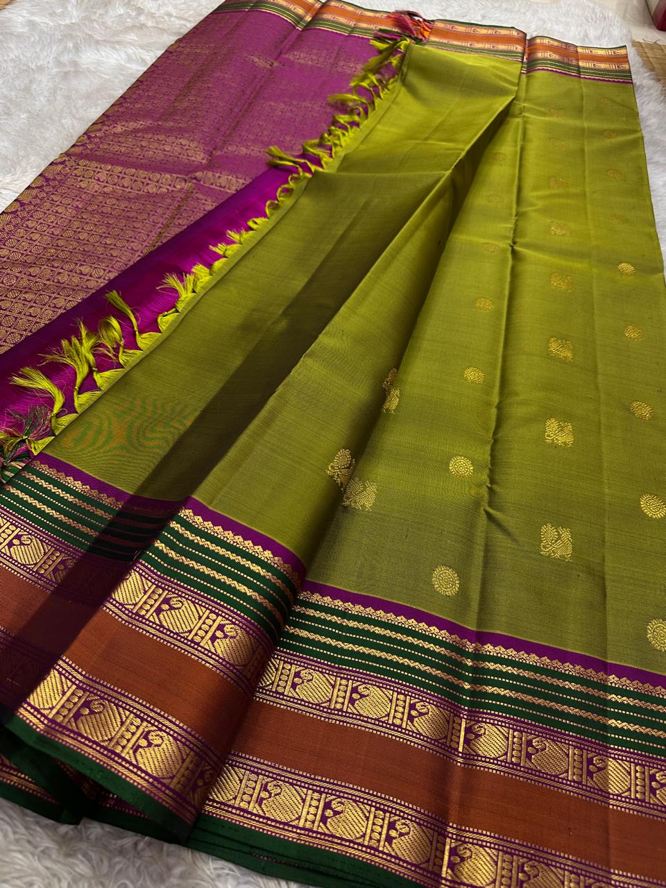 Meadow Bloom ✨ – Pure Kanchipuram Silk Saree
Meadow Green Body with Gold Zari Buttas
Contrast Brown–Green Border with Peacock Motifs
Majestic Magenta-Pink Zari Brocade Pallu
Handwoven Elegance – Perfect for Weddings & Festive Wear