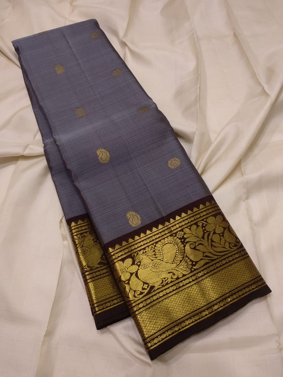 Handwoven Kanchi Pattu Butta saree combining a quiet shot-colour body and ornate peacock pallu