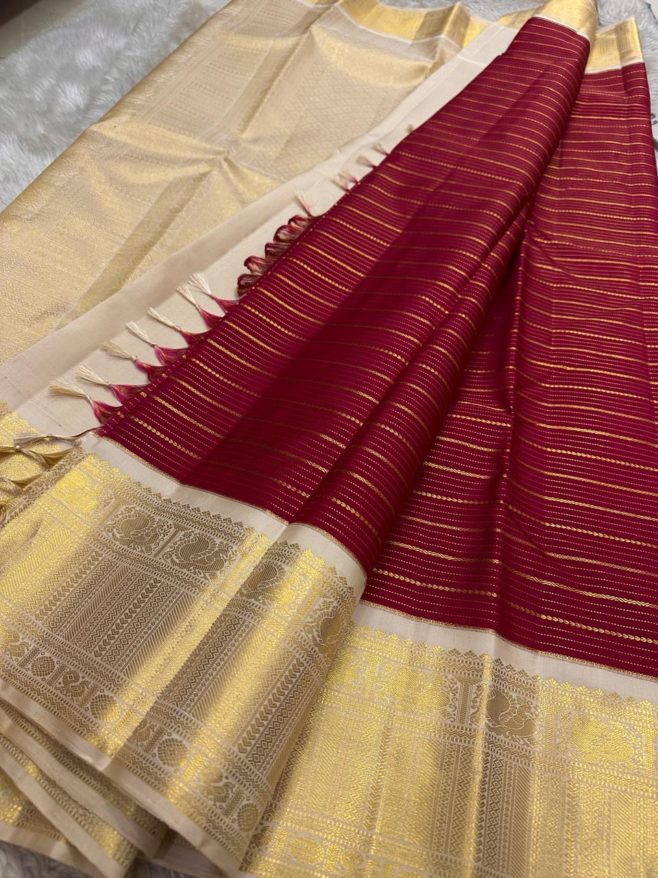 Draped view showing red striped pleats, ivory panel and lustrous gold temple border in Kanchipuram silk