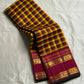 Manjal Maroon Kattam – Pure Kanchipuram Silk Saree
Mustard & Maroon Body with Traditional Multi-Color Checks
Korvai Borders with Floral-Star Zari & Temple Tips
Grand Maroon Pallu with Gold Zari Stripes & Tassels
Silk Mark Certified | ships in 2 weeks