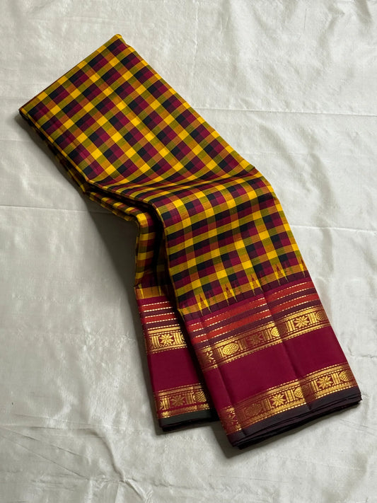Manjal Maroon Kattam – Pure Kanchipuram Silk Saree
Mustard & Maroon Body with Traditional Multi-Color Checks
Korvai Borders with Floral-Star Zari & Temple Tips
Grand Maroon Pallu with Gold Zari Stripes & Tassels
Silk Mark Certified | ships in 2 weeks